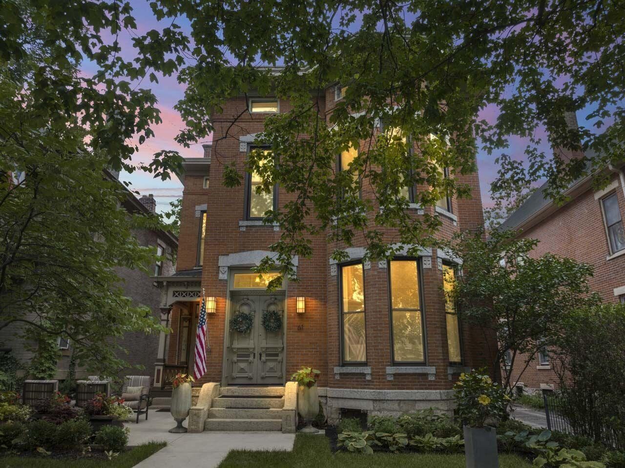 61 W 2nd Avenue, a sold three-story brick home in Columbus's Italian Village at dusk